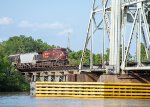 A westbound grain train starts across the Neches River Lift Bridge